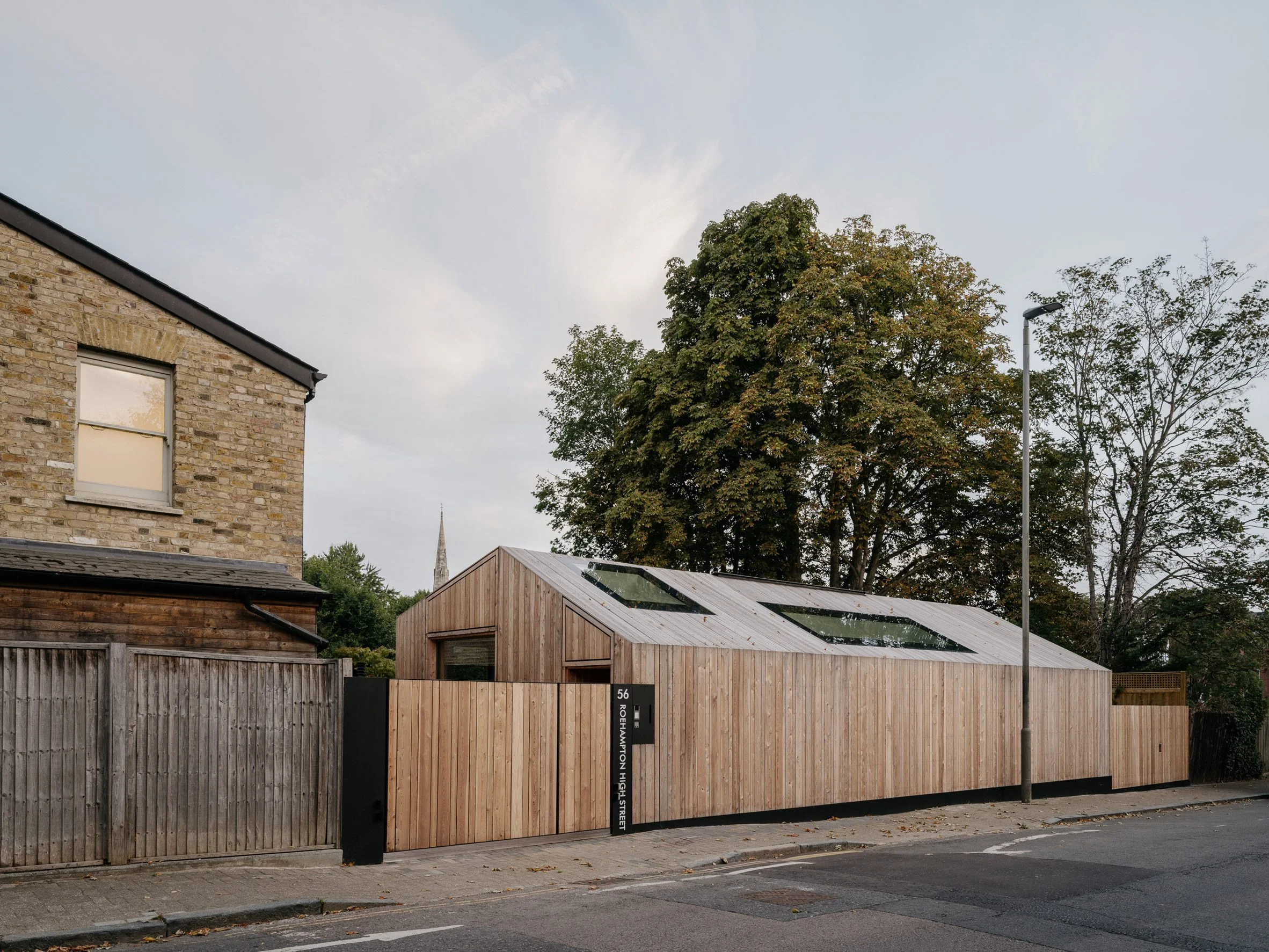 Street-facing view of the partially submerged house behind a timber fence